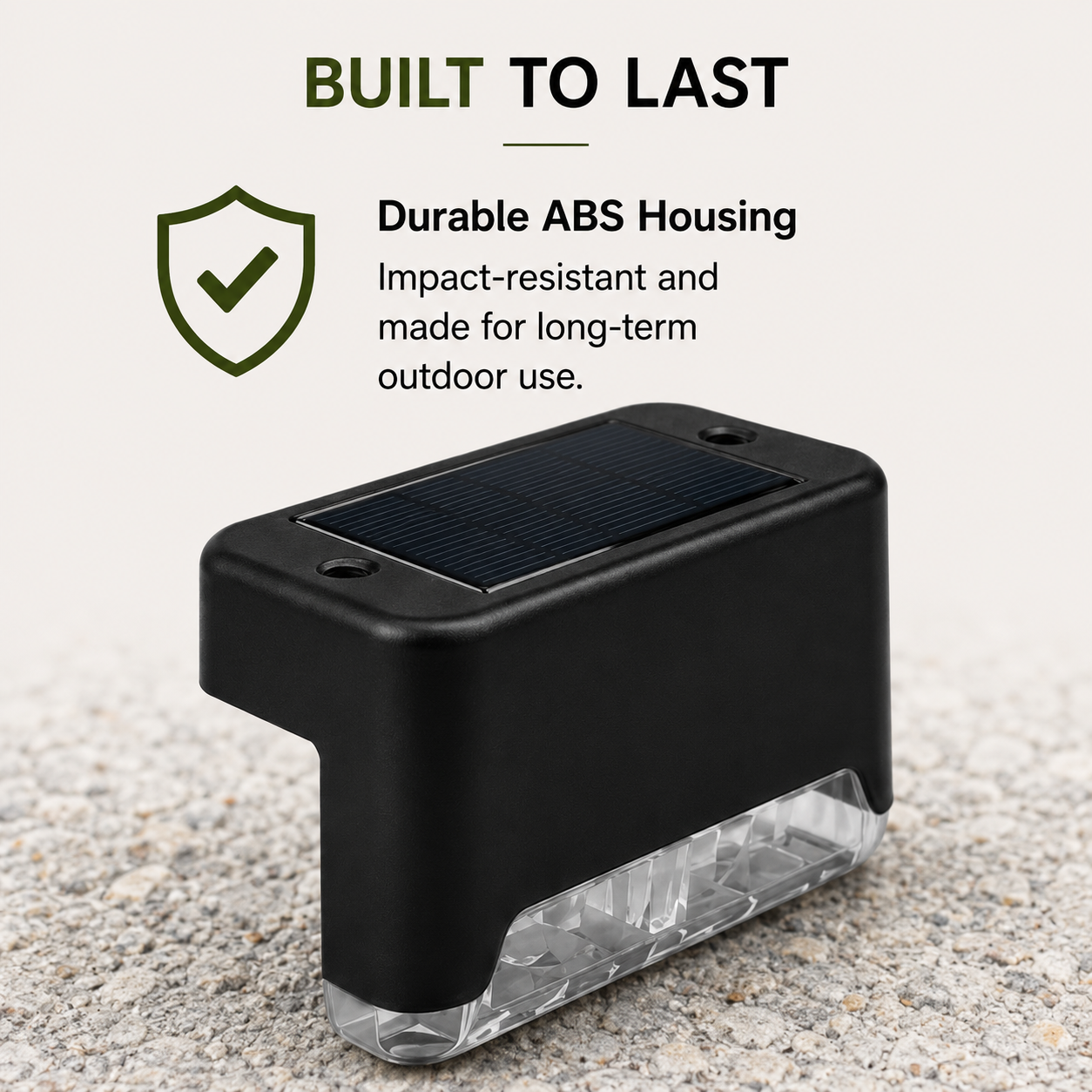 A black rectangular solar-powered outdoor light with a clear bottom lens, shown on a light textured surface with marketing text reading 'BUILT TO LAST' and 'Durable ABS Housing'.